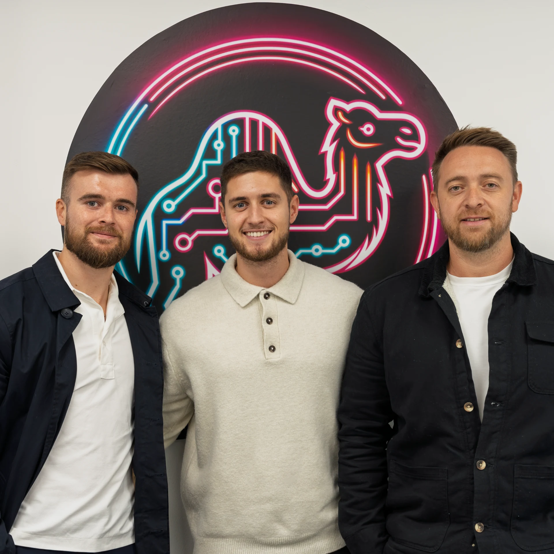 The Digital Camel team: Jack Fearon, Ethan and Jack Lawson in front of the neon camel emblem